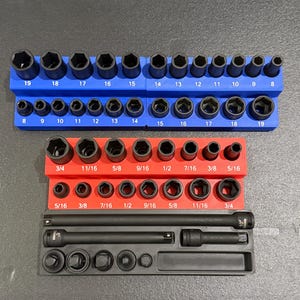 May include: A set of black socket wrenches in a blue and red organizer. The wrenches are arranged by size, with measurements in inches. Includes a black extension bar and additional sockets.