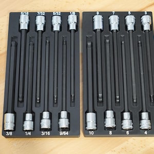 May include: Two black tool organizers with a variety of hex bit sockets and drivers. The sockets are labeled with fractional inch measurements, including 5/16, 7/32, 5/32, 1/8, 3/8, 1/4, 3/16, and 9/64.