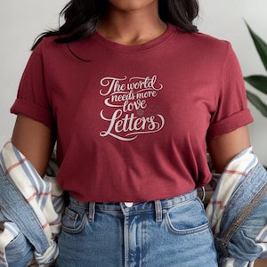 O mundo precisa de mais cartas de amor, camiseta com cores confortáveis, camiseta com caligrafia romântica, camiseta estética com tinta vintage, camiseta com carta de amor escrita à mão