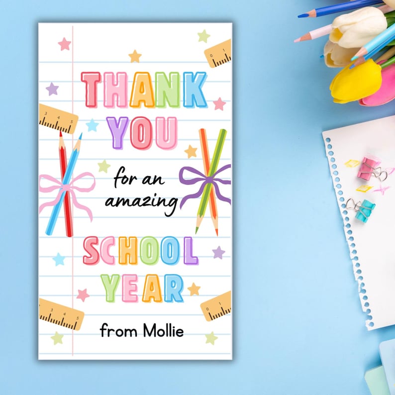 K&ouml;nnte beinhalten: Eine wei&szlig;e Karte mit dem Text "THANK YOU for an amazing SCHOOL YEAR from Mollie." Der Text ist in bunten Buchstaben gehalten. Die Karte ist mit Bleistiften, Schleifen, Sternen und Linealen verziert.