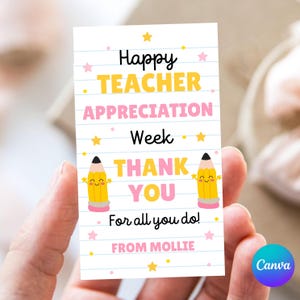 May include: A white card with the text "Happy Teacher Appreciation Week THANK YOU For all you do!" in black, yellow, and pink. Two yellow cartoon pencils with smiling faces are on the card. The card is held in a person's hand.