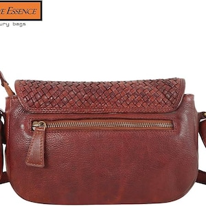 May include: A dark red leather crossbody bag featuring a woven texture on the top flap and a zippered pocket on the front. The bag includes a shoulder strap attached with brass-toned metal hardware. The text Native Essence Luxury bags is visible.