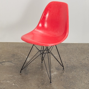 May include: A red plastic chair with a black metal frame. The chair has a simple, modern design.