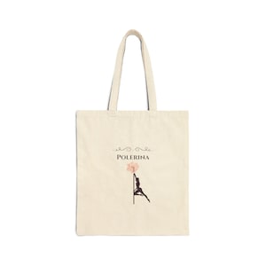 Può includere: Una borsa tote beige con una silhouette nera di una donna su un palo con un fiore rosa in cima. Il testo "POLERINA" è stampato sopra l'immagine.