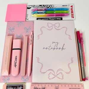 May include: A stationery set including a notebook with the text my notebook, a pack of three Zebra Z-Grip pens, pink sticky notes, a Bic highlighter, a pen with the text YOU ARE LOVED, pencils, and a 15 cm Ashton & Wright ruler.