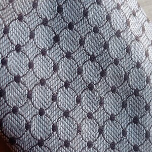 Vintage BAGOZZA MILANO necktie made in Italy from 100% pure silk. Features an elegant grey geometric pattern with a subtle sheen, representing classic Italian menswear design. This luxury tie is in great vintage condition, ideal for collectors or anyone seeking timeless formal accessories. Perfect for pairing with suits, businesswear, or dress shirts, this piece offers sophistication and heritage craftsmanship.
