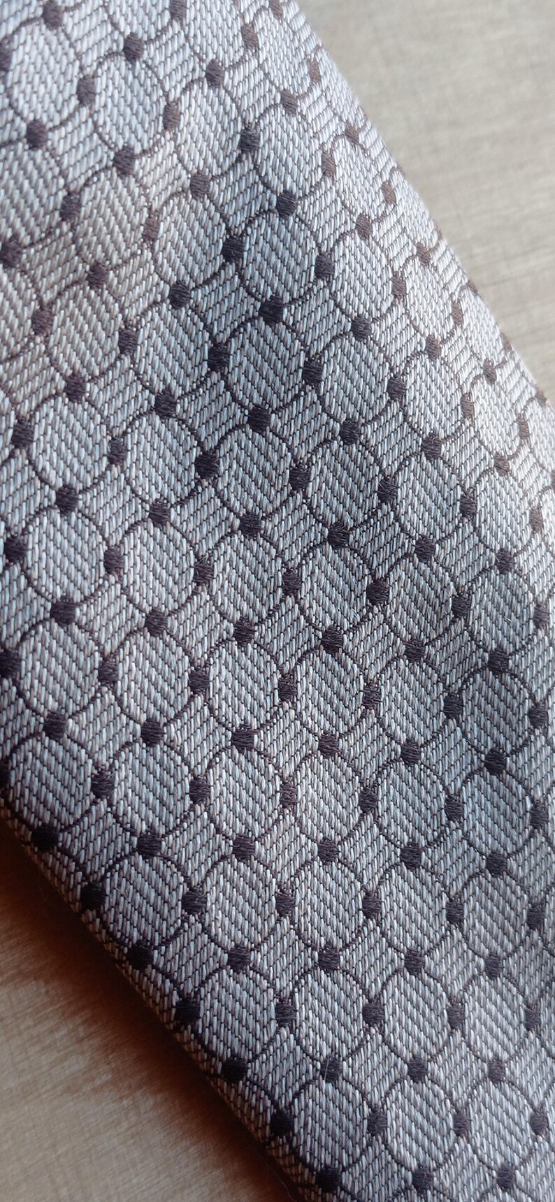 Vintage BAGOZZA MILANO necktie made in Italy from 100% pure silk. Features an elegant grey geometric pattern with a subtle sheen, representing classic Italian menswear design. This luxury tie is in great vintage condition, ideal for collectors or anyone seeking timeless formal accessories. Perfect for pairing with suits, businesswear, or dress shirts, this piece offers sophistication and heritage craftsmanship.