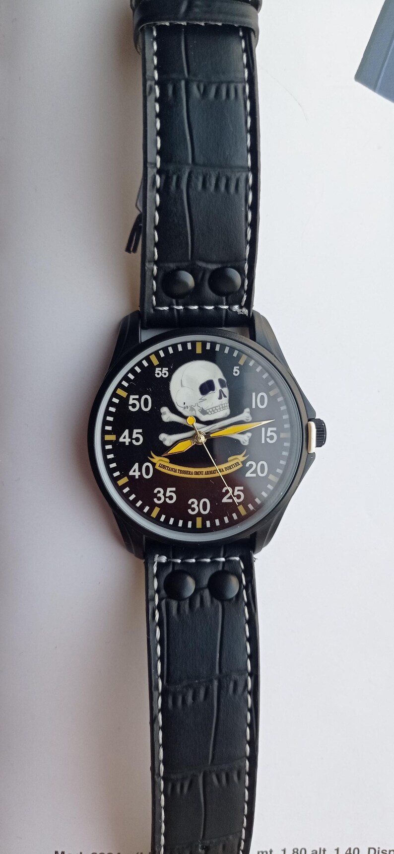 Men’s military quartz wristwatch inspired by the Spanish Army 8th Cavalry Regiment “Lusitania,” featuring a bold black dial with striking skull and crossbones emblem, a symbol of bravery, courage, and sacrifice. This collectible watch includes a precise quartz movement, durable black case, and a black leather strap with white stitching. Perfect for military history collectors, army enthusiasts, and men’s fashion lovers, this unworn timepiece represents unique heritage, bold design.