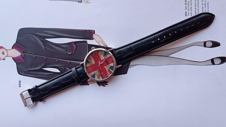 New wristwatch featuring the Union Jack (British flag) on the dial, with a black faux leather strap and silver buckle. Unused quartz timepiece, stylish and perfect for fans of British culture or punk fashion.