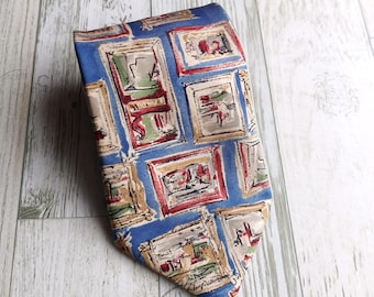 May include: Blue necktie with a repeating pattern of framed artwork in red, green, and beige. The tie is made of a smooth fabric and is displayed on a light-colored wooden surface. The artwork frames are rectangular.