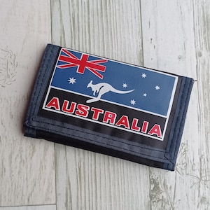 May include: A tri-fold wallet with a blue and black design. The front features the Australian flag, a kangaroo, and the word "AUSTRALIA" in red and white. The wallet is made of a durable material.