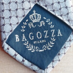 Vintage BAGOZZA MILANO necktie made in Italy from 100% pure silk. Features an elegant grey geometric pattern with a subtle sheen, representing classic Italian menswear design. This luxury tie is in great vintage condition, ideal for collectors or anyone seeking timeless formal accessories. Perfect for pairing with suits, businesswear, or dress shirts, this piece offers sophistication and heritage craftsmanship.