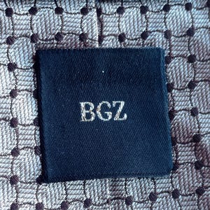 Vintage BAGOZZA MILANO necktie made in Italy from 100% pure silk. Features an elegant grey geometric pattern with a subtle sheen, representing classic Italian menswear design. This luxury tie is in great vintage condition, ideal for collectors or anyone seeking timeless formal accessories. Perfect for pairing with suits, businesswear, or dress shirts, this piece offers sophistication and heritage craftsmanship.
