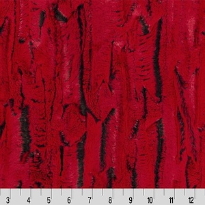 May include: A vibrant red faux fur fabric with a deep black vertical striped pattern. A white ruler is positioned along the bottom edge, showing measurements from 1 to 15 inches, indicating the scale of the textured, plush material surface.