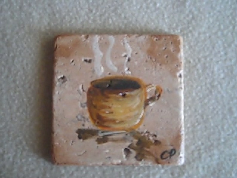 K&ouml;nnte beinhalten: Eine braune und beige Keramikfliese mit einem gemalten Bild einer Kaffeetasse mit aufsteigendem Dampf. Die Fliese hat einen rustikalen Look und die Tasse ist realistisch gemalt. Die Fliese ist mit "CP" signiert.