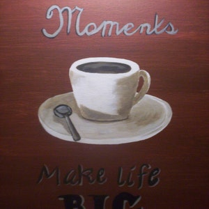 Op de afbeelding: Een schilderij van een witte koffiekop met een bruine schotel en een lepel op een rode achtergrond. De tekst "Little Moments Make Life BIG" staat op het schilderij.