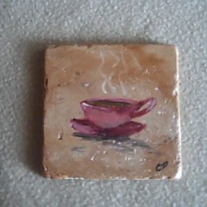 K&ouml;nnte beinhalten: Ein handbemalter Keramik-Untersetzer mit einer rosa Kaffeetasse, aus der Dampf aufsteigt. Die Fliese hat einen braunen Hintergrund mit einer dezenten Textur.