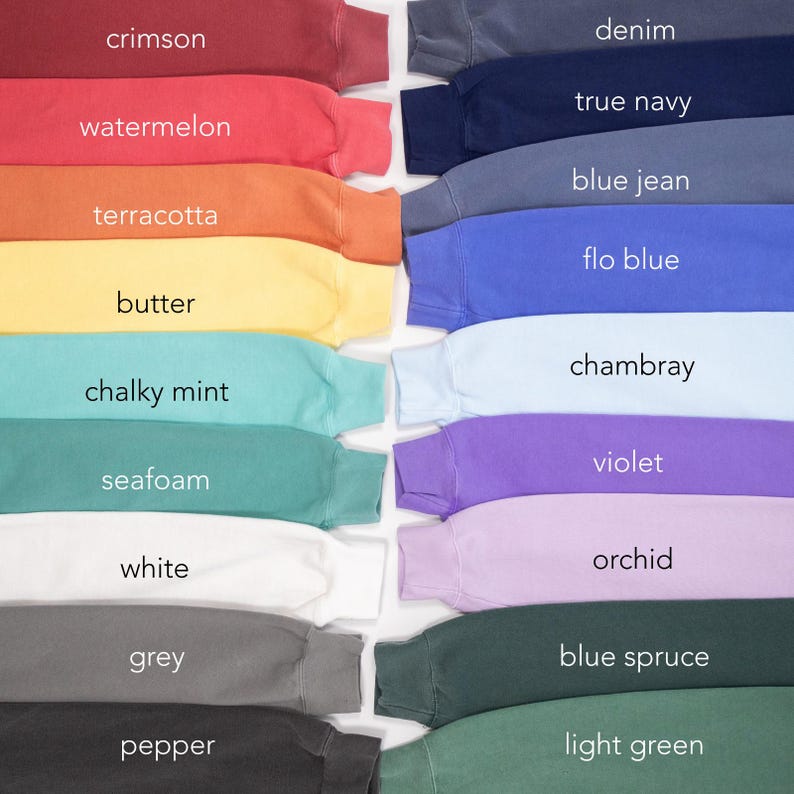 Pode incluir: Uma cole&ccedil;&atilde;o de camisolas de gola redonda em v&aacute;rias cores, incluindo carmesim, melancia e terracota. Outras cores incluem ganga, azul marinho e azul jeans. Cada camisola exibe o seu nome de cor, como "manteiga" e "hortel&atilde; giz".