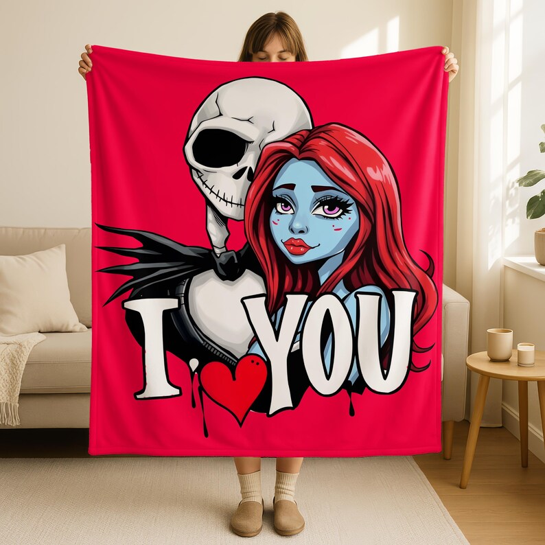 A woman is holding up a large red blanket with a cartoon illustration of a skeleton and a woman's face on it.