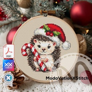 May include: A cross-stitch pattern featuring a hedgehog wearing a Santa hat and holding a candy cane. The design is set in a wooden embroidery hoop. The background includes Christmas ornaments and a pine cone.