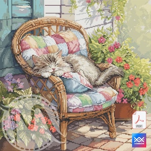 Puede incluir: Un patrón de punto de cruz representa un gato atigrado durmiendo en una silla de mimbre en un patio soleado. La silla tiene un cojín de retazos colorido. Flores rojas y rosas están en macetas cerca.
