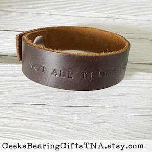 Pas tous ceux qui s&#39;aventurent, bracelet manchette en cuir avec finition vieillie et citation de Tolkien. Par des geeks avec des cadeaux.