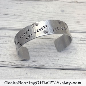 Not All Those Who Wander...3/4 inch wide, hammered aluminum bracelet with an inspiring quote from JRR Tolkien. By Geeks Bearing Gifts.
