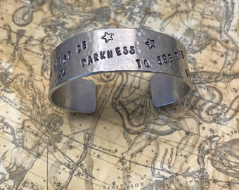 Three quarter inch cuff bracelet with Ursala LeGuin quote: There must be darkness to see the stars.