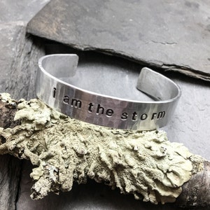 I AM THE STORM, 0.5 inch wide, hammered aluminum cuff bracelet with inspirational quote