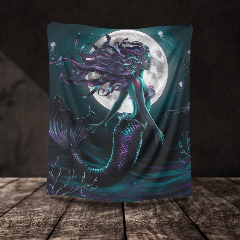 May include: A tapestry featuring a mermaid with long, flowing purple hair and a teal tail. The mermaid is swimming in front of a full moon with a dark blue background. The tapestry is decorated with jellyfish and coral.