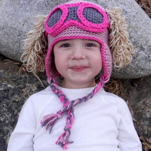 Pink aviator rescue dog crochet hat pattern with earflaps, goggles, and furry ears