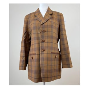 May include: A brown plaid blazer with a classic design. The blazer features a notched collar, three brown buttons, and two front pockets. The plaid pattern includes shades of brown, blue, and green. The blazer is displayed on a white mannequin.