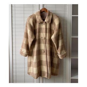 May include: A vintage, knee-length coat in a plaid pattern of beige and brown. The coat features a classic collar, three large buttons, and two front pockets. The sleeves are cuffed, and the coat hangs on a wooden hanger.