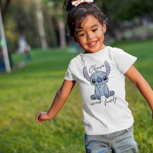 Op de afbeelding: Een wit T-shirt met een blauw Stitch-personage uit de film Lilo & Stitch. Op het shirt staat "Ohana means family".
