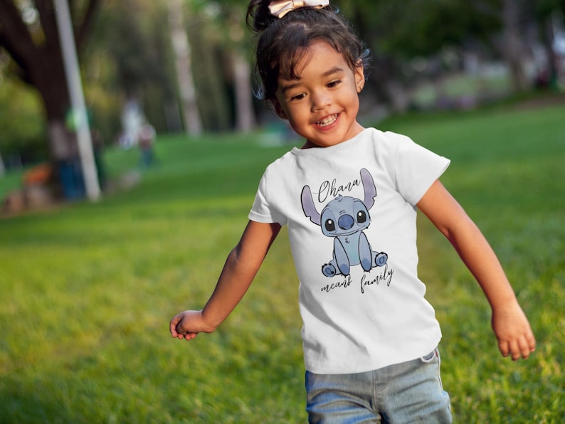 Op de afbeelding: Een wit T-shirt met een blauw Stitch-personage uit de film Lilo & Stitch. Op het shirt staat "Ohana means family".