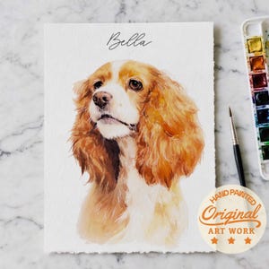 Puede incluir: Pintura a la acuarela de un perro Cocker Spaniel con pelaje marr&oacute;n y blanco. El nombre del perro, "Bella", est&aacute; escrito encima del retrato. La obra de arte est&aacute; etiquetada como "Hand Painted Original Art Work".