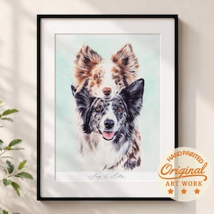 May include: A framed portrait featuring a watercolor-style illustration of two dogs stacked vertically. The top dog is brown and white, while the bottom dog is black, white, and gray. The text "Joy & Lila" is printed below the dogs.