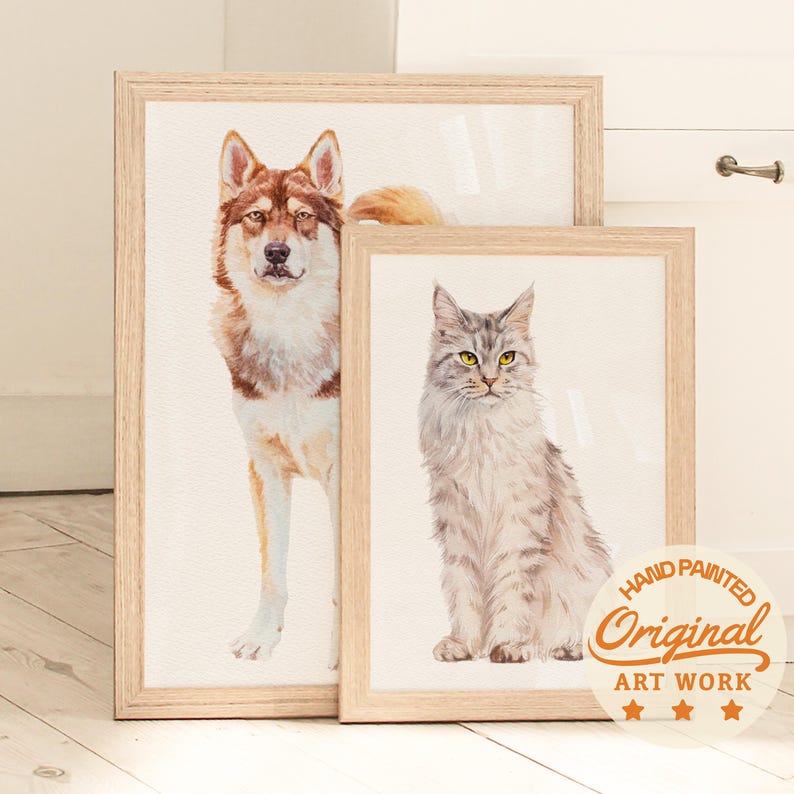 Puede incluir: Dos pinturas en acuarela enmarcadas de animales. Una representa un perro marr&oacute;n y blanco, la otra un gato gris con ojos amarillos. Ambas est&aacute;n en marcos de madera clara. Una pegatina en la parte inferior derecha dice "Hand Painted Original Art Work."