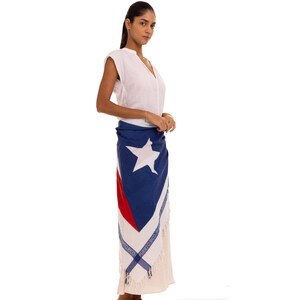 May include: A white sleeveless V-neck top paired with a wrap skirt featuring the Puerto Rican flag design. The skirt displays a large white star on a blue triangle, red and white stripes, and a border with the text Puerto Rico printed repeatedly.