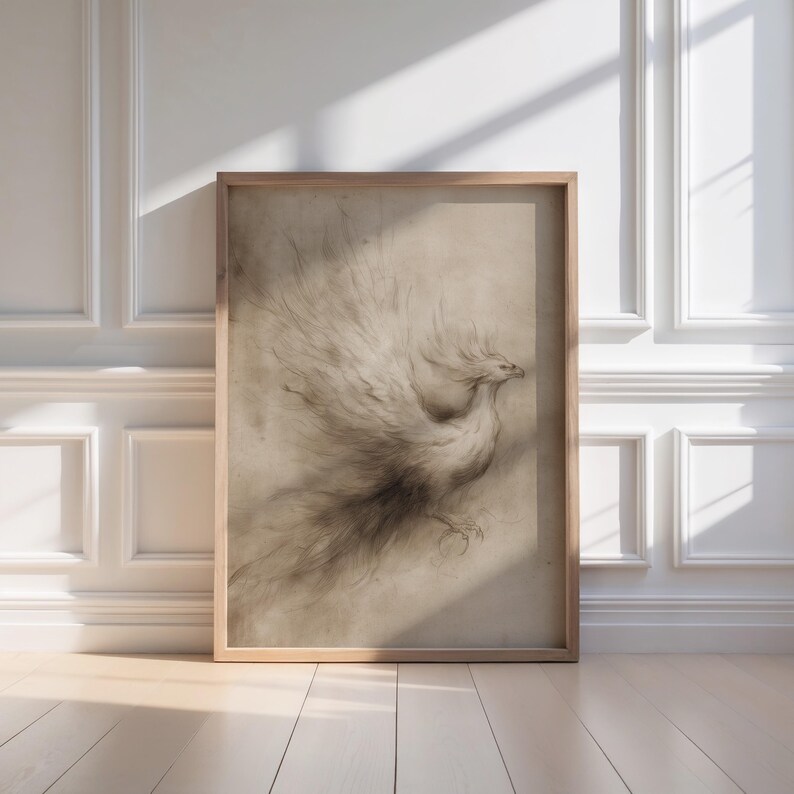 A delicate phoenix sketch is elegantly framed in light wood, casting a warm glow in a sunlit, sophisticated room, perfect for fantasy wall art enthusiasts. This vintage art piece brings a touch of magical creatures into a literary haven.