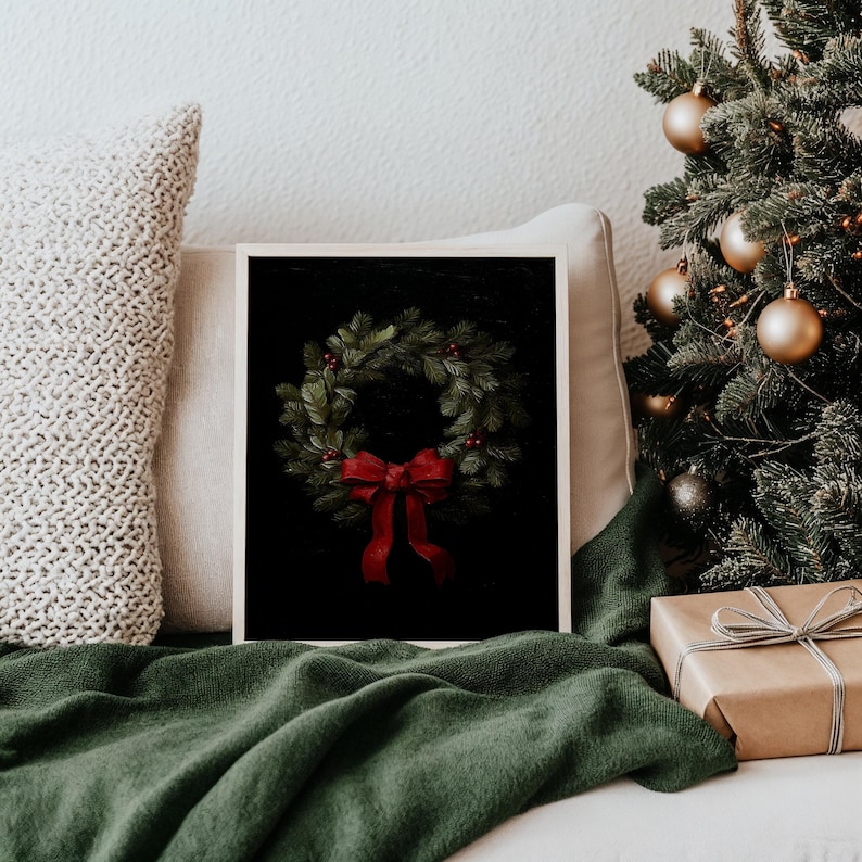 A natural wood-framed wreath print exudes festive charm amid cozy holiday decor, nestled beside a lush Christmas tree and comfy knit pillow, capturing a mood of classic elegance and winter wonderland delight.