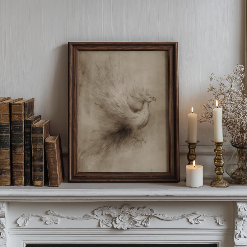 A vintage sketch of a phoenix in an ornate frame rests on a classic mantel alongside antique books and elegant brass candlesticks, creating a literary wall art atmosphere. The phoenix wall art exudes a whimsical and magical vibe in this cozy setting.
