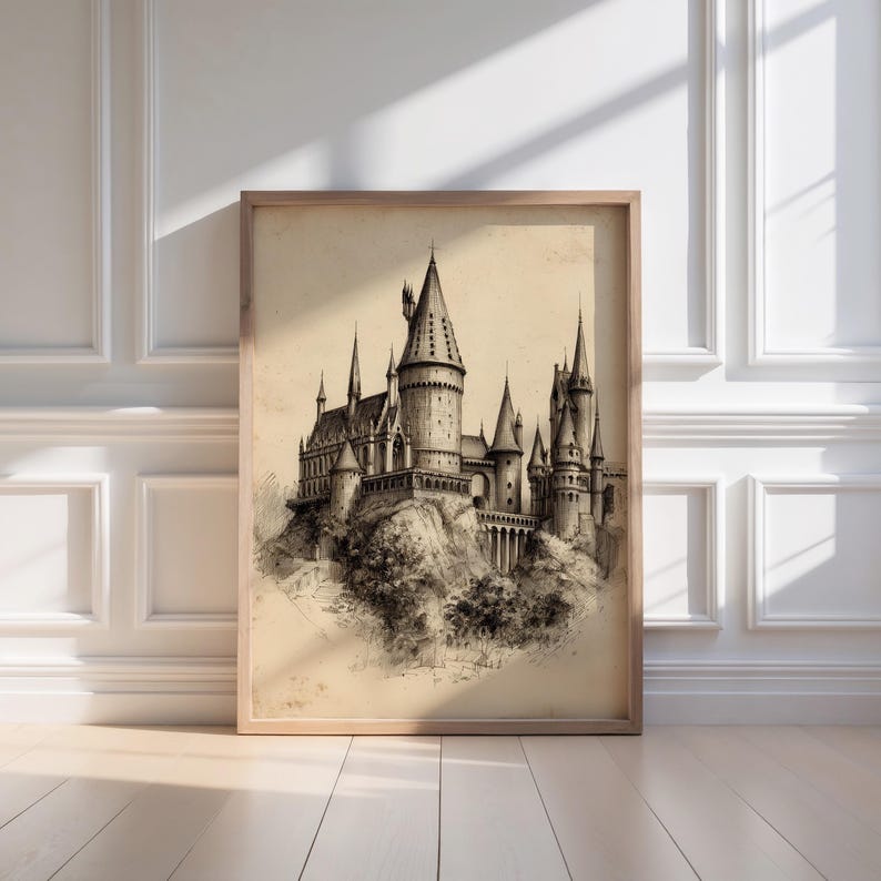 A vintage sketch of a castle, reminiscent of a wizard school, rests elegantly in a minimalist wooden frame against a sunlit white paneled wall. The artwork exudes a moody art vibe, perfect for wizarding decor enthusiasts.