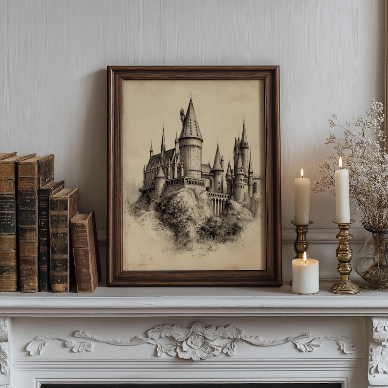 A vintage castle sketch is elegantly framed in dark wood, resting on a white mantel adorned with antique books and candlelit brass holders, creating a moody ambiance perfect for wizard room decor. 

The enchanting wizard school art adds a touch of fantasy wall art to a cozy, timeless setting with its intricate details and whimsical charm.