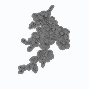 Könnte beinhalten: Eine graue Plastikform zum Backen oder Dekorieren von Kuchen mit einem Kirschblütenzweig-Design.