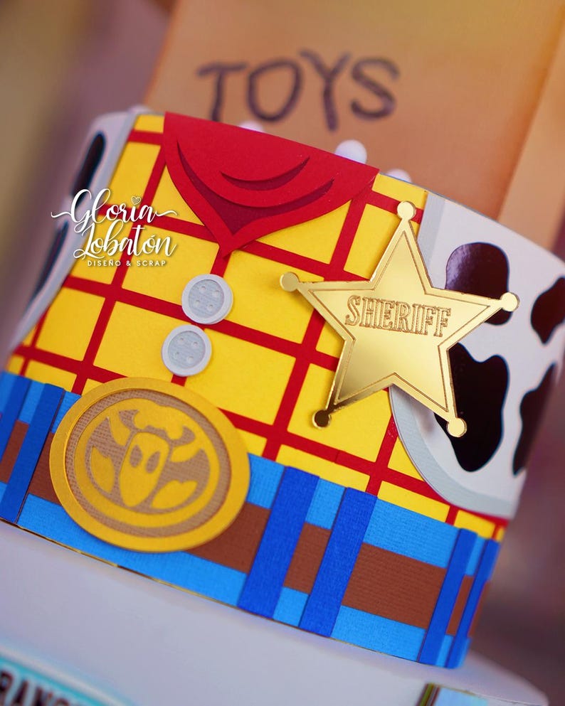 May include: A close-up of a decorative item resembling a sheriff's vest from the movie Toy Story. The item features a yellow background with a red plaid pattern, a gold sheriff's badge, and a brown and white cowhide pattern.