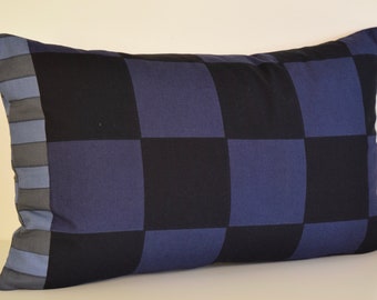 Puede incluir: Una almohada de tiro a cuadros azules y negros con un borde gris y azul.