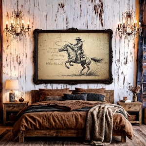 May include: A rectangular wall art print in a dark ornate frame featuring a black ink illustration of a cowboy riding a horse. The text reads: You can't be scared of the things that make you FEEL ALIVE. The background has a vintage paper texture.