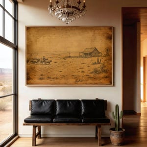 Könnte beinhalten: Ein gerahmter Sepia-Druck zeigt eine Western-Landschaft mit einem Haus, einer Windmühle und Reitern. Das Kunstwerk hängt über einer schwarzen Lederbank. Ein Kaktus in einem Terrakotta-Topf steht daneben.