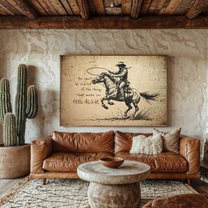 May include: A rectangular wall art print featuring a sepia-toned illustration of a cowboy riding a bucking horse while holding a lasso. The text reads: You can't be scared of the things that make you FEEL ALIVE. The artwork has a weathered, vintage paper texture.